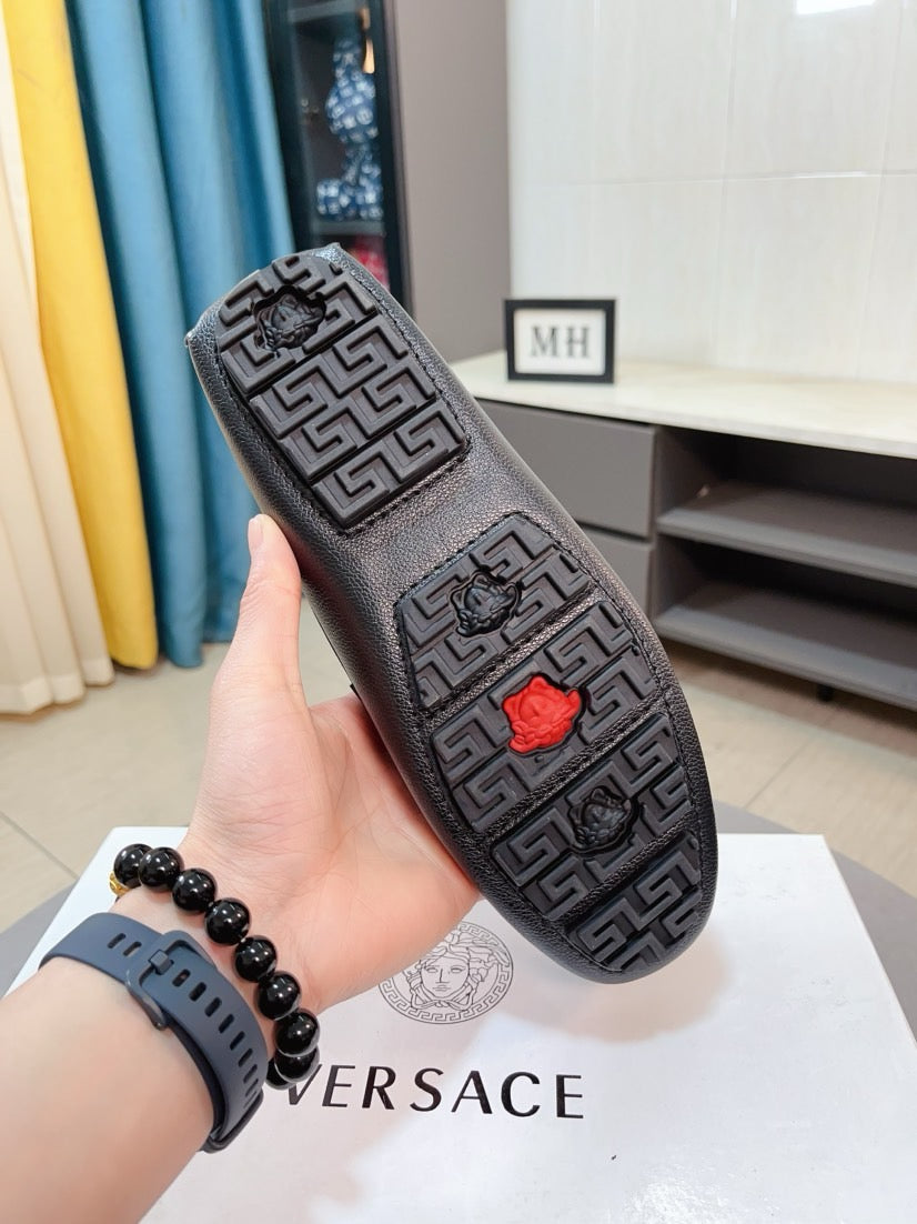 Black patterned leather loafer with red rose emblem and geometric logo print