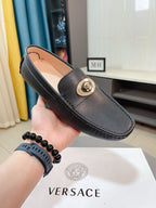 Black leather loafer with gold medallion buckle and cushioned collar