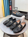 Black leather loafer with gold bar-medallion detail and textured finish