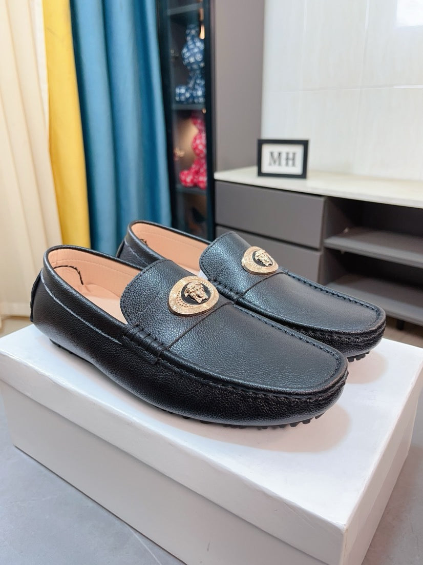 Black leather loafer pair with gold medallion front straps