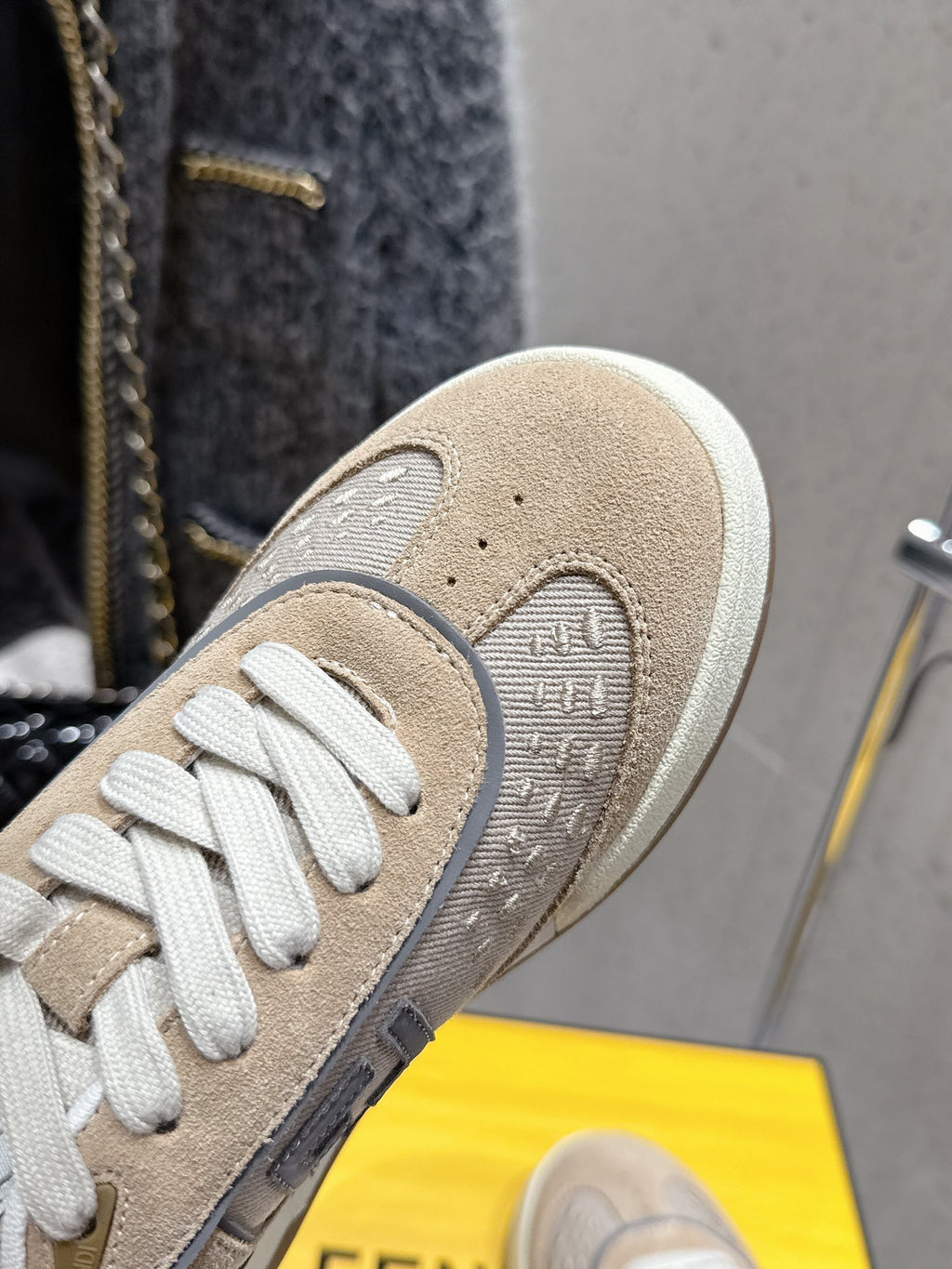 Fendi unisex sneaker close-up of toe and textured beige upper with white laces