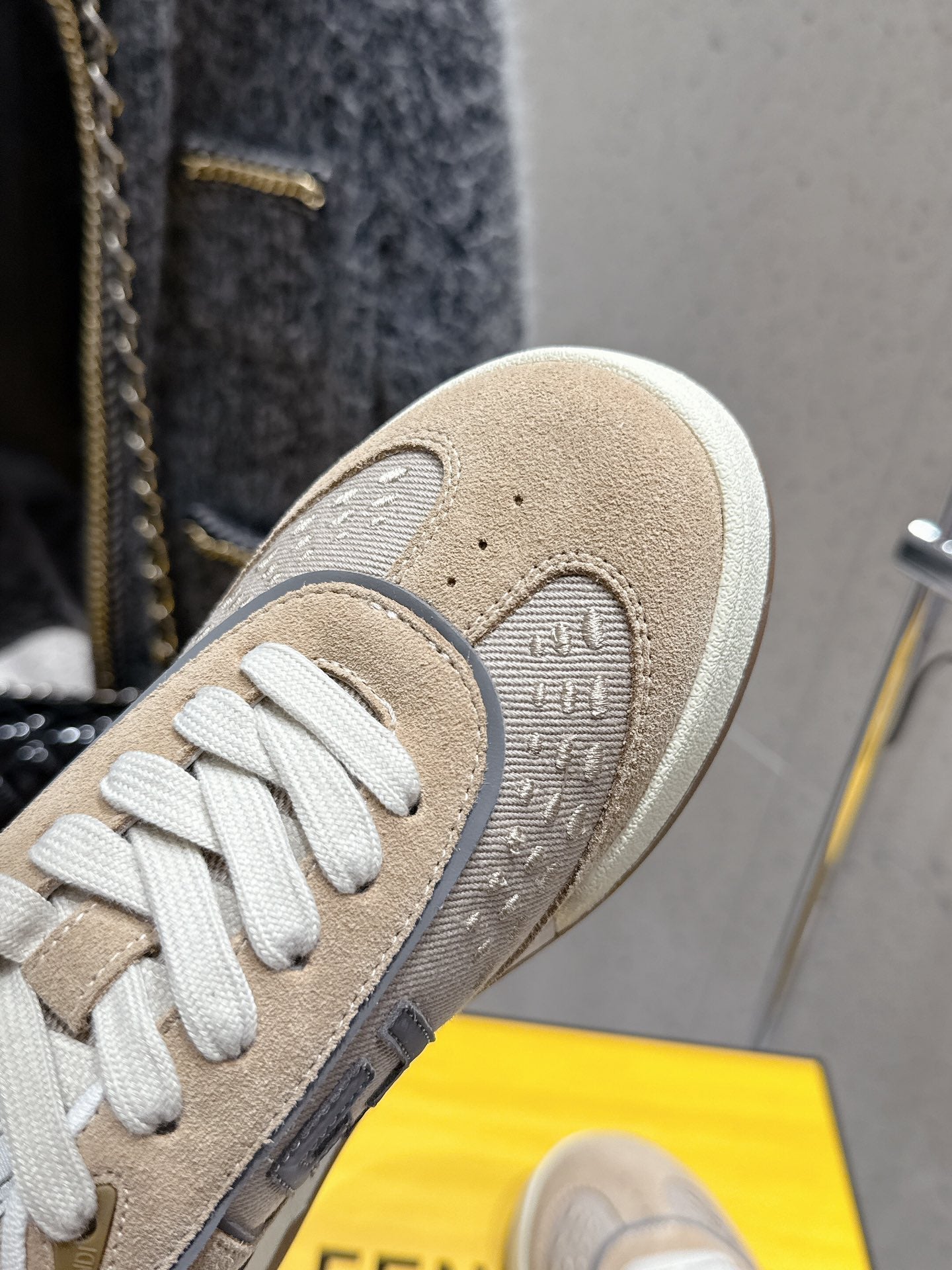 Fendi unisex sneaker close-up of toe and textured beige upper with white laces