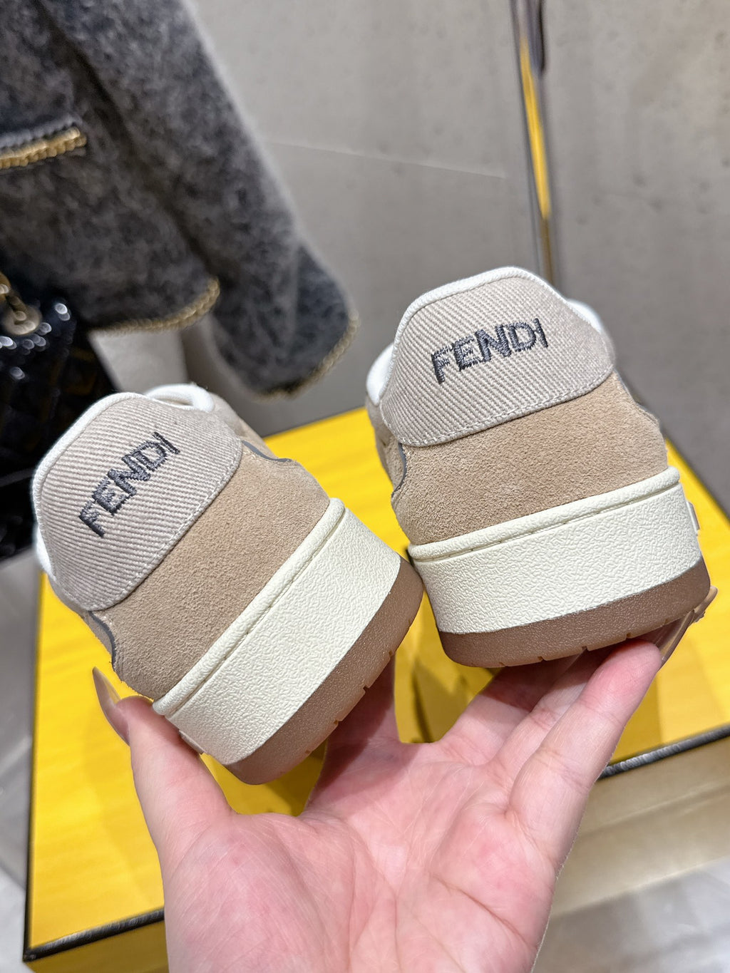 Fendi unisex sneakers heel view, beige uppers with white sole and FENDI text tab