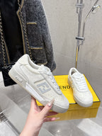 Fendi unisex sneakers, white leather, close-up with hand holding one shoe
