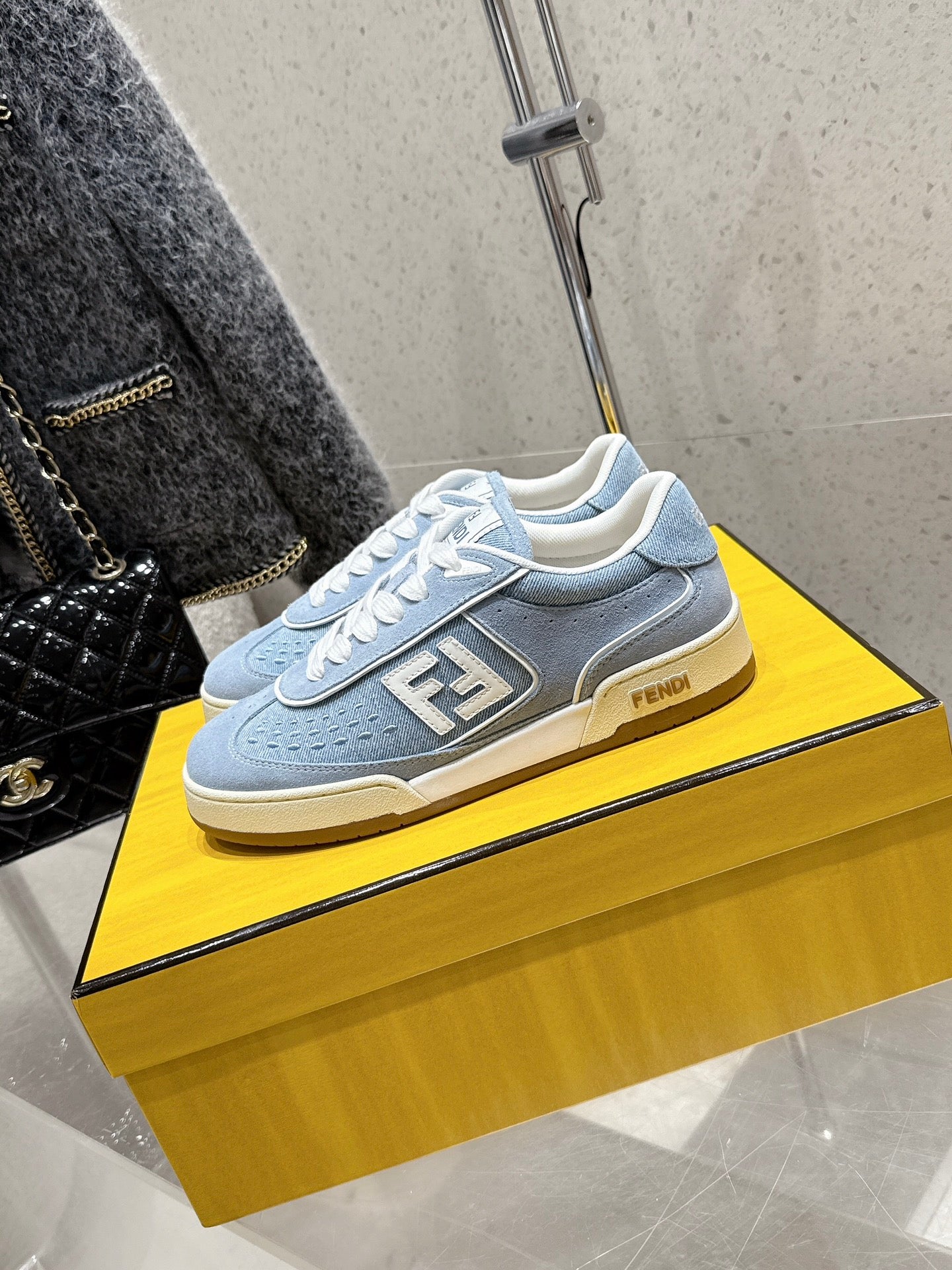 Light blue Fendi sneakers with white laces and front F emblem, beige sole