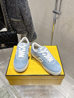Pair of light blue Fendi sneakers with white laces and F logo on beige soles