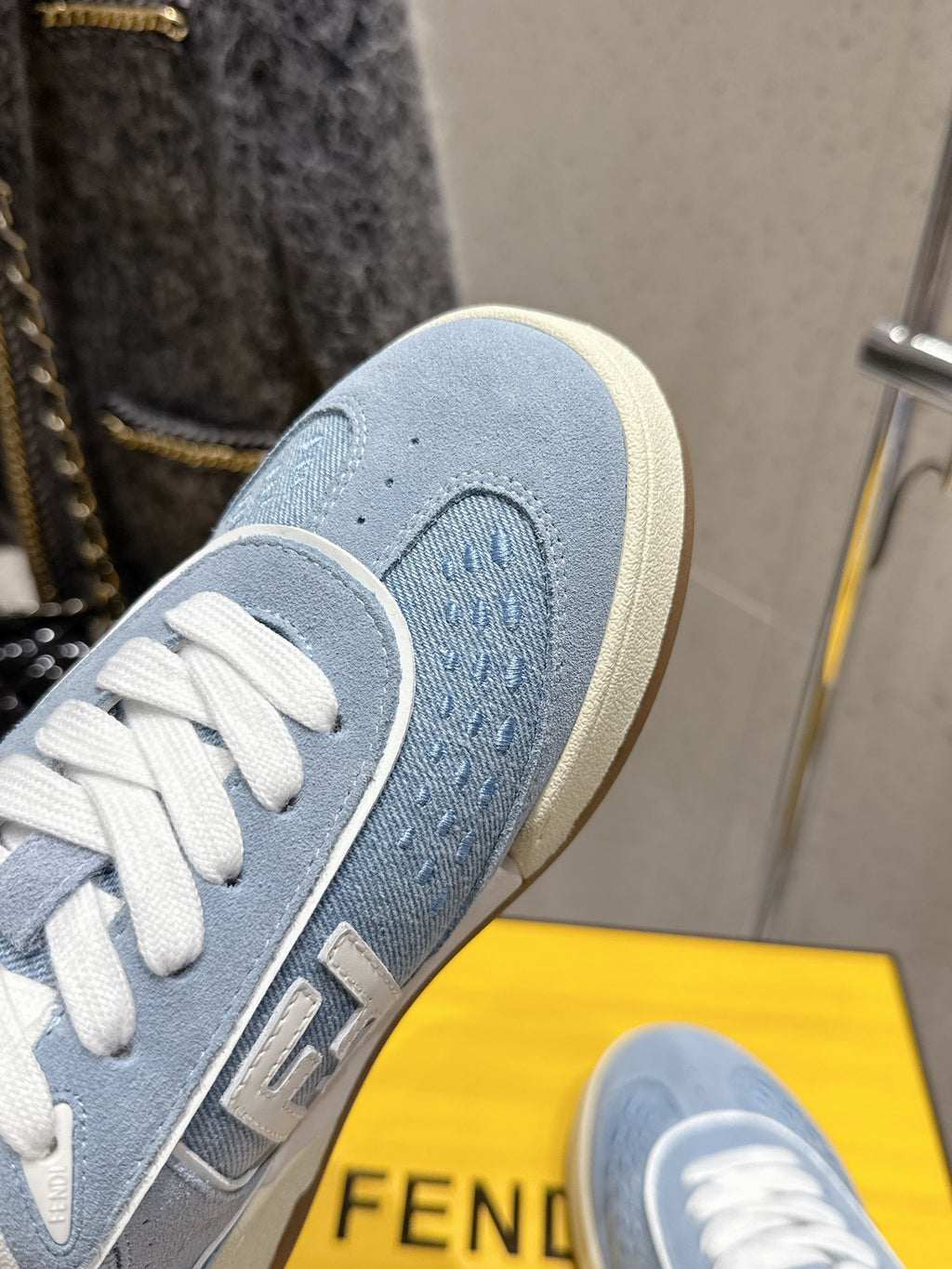 Close-up of light blue Fendi sneaker side with textured panel and white laces