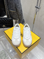 White Fendi unisex sneakers, perforated toe and lace-up front on display