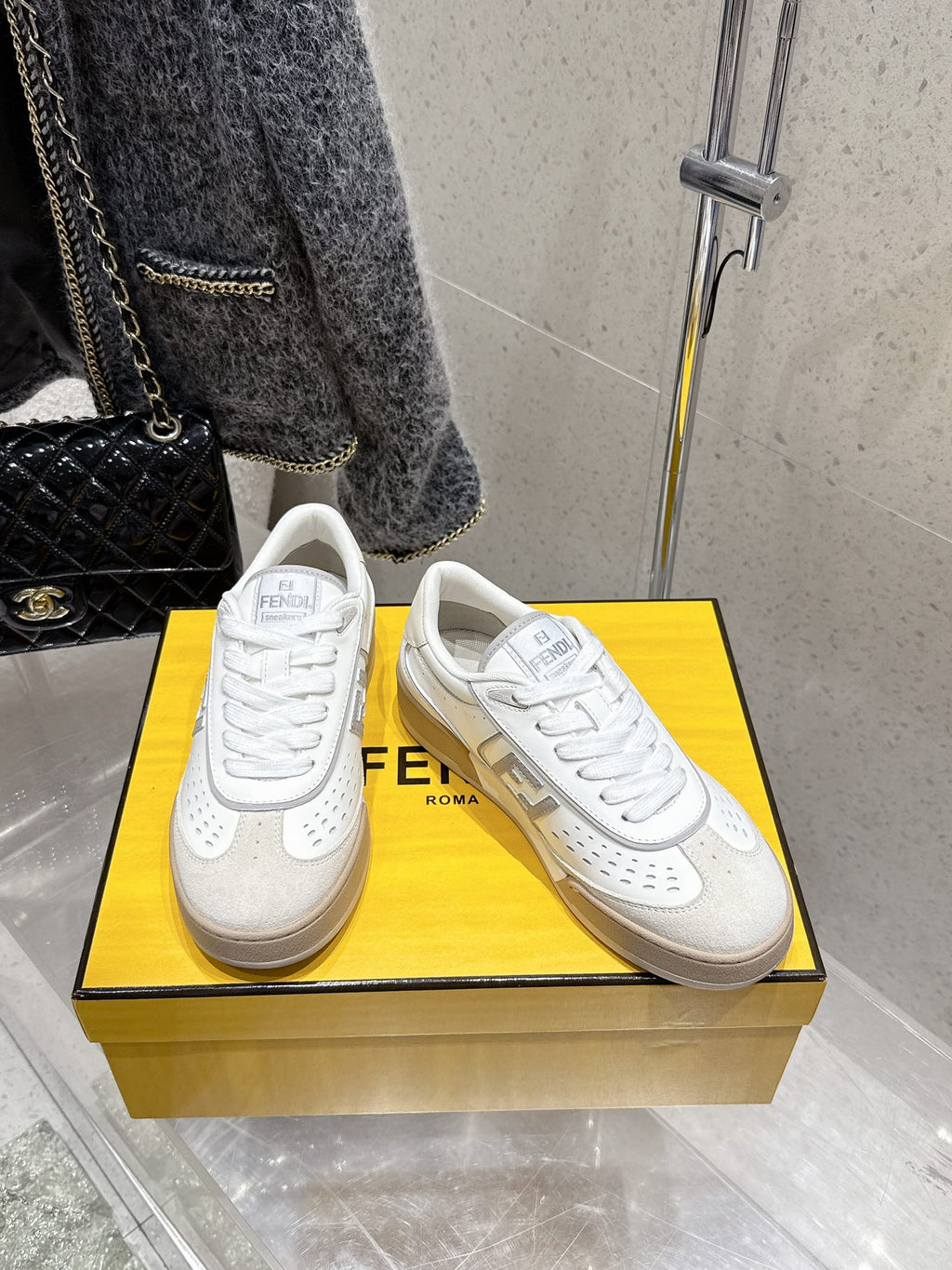 White Fendi sneakers on display, side FF logo and lace-up design