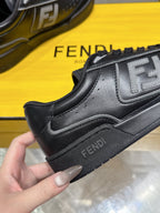 Black Fendi sneaker close-up on yellow box, side FF logo and lace-up collar
