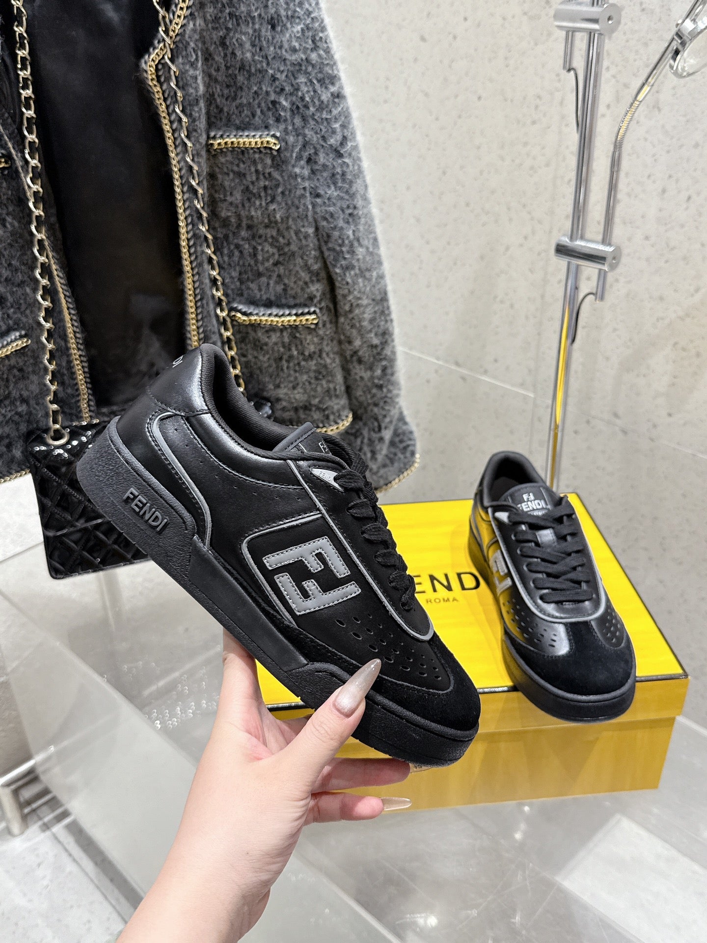 Fendi unisex sneakers, black with FF patch and lace-up front, shown in hand