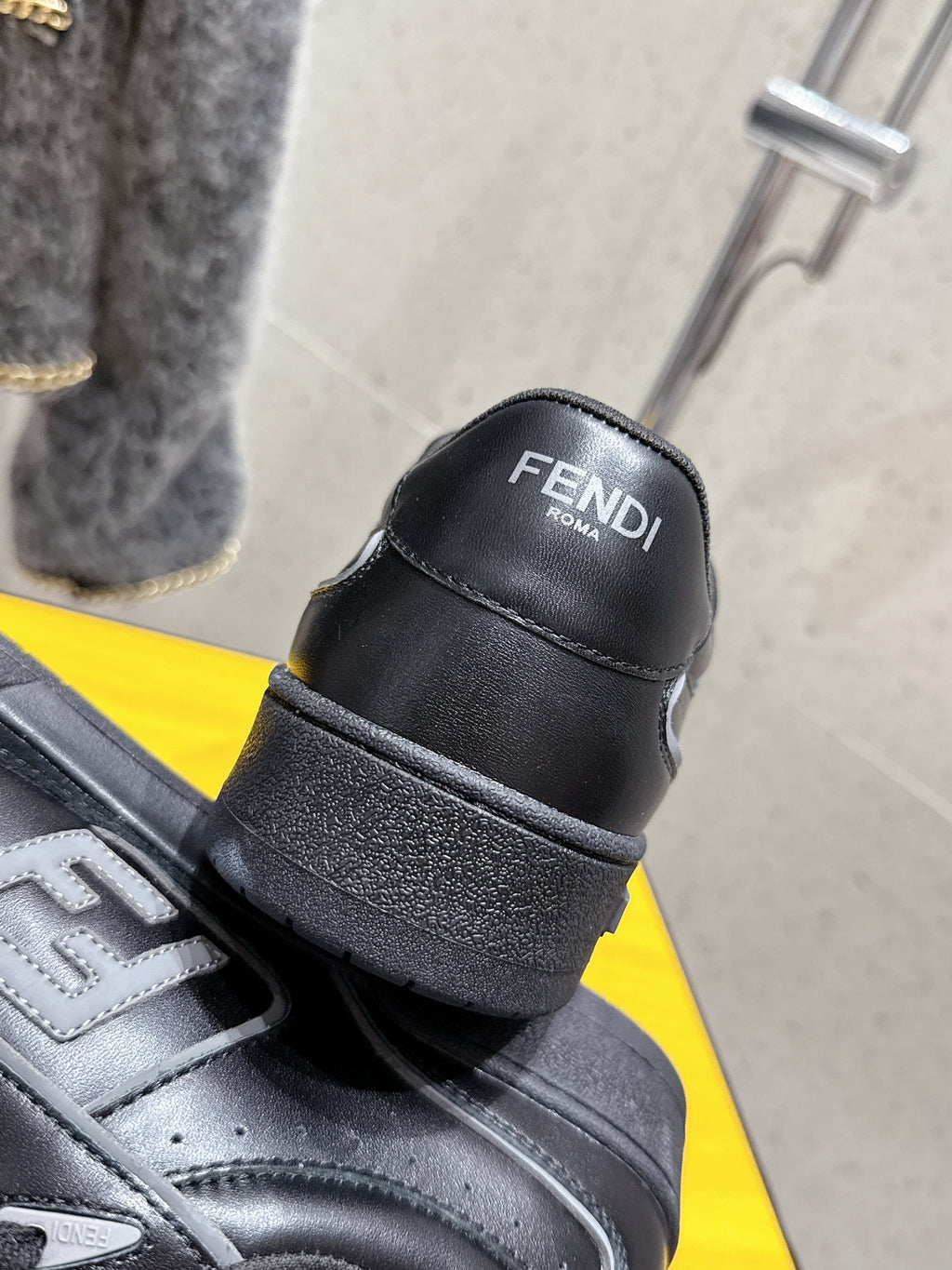 Fendi unisex sneakers heel view, black leather with FENDI logo and strap detail