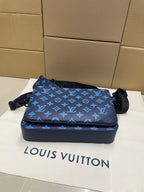 Blue monogram crossbody bag with long strap and zipper front pouch flap