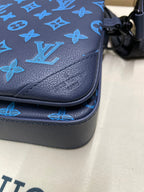 Blue leather crossbody corner with monogram pattern and stitched edge