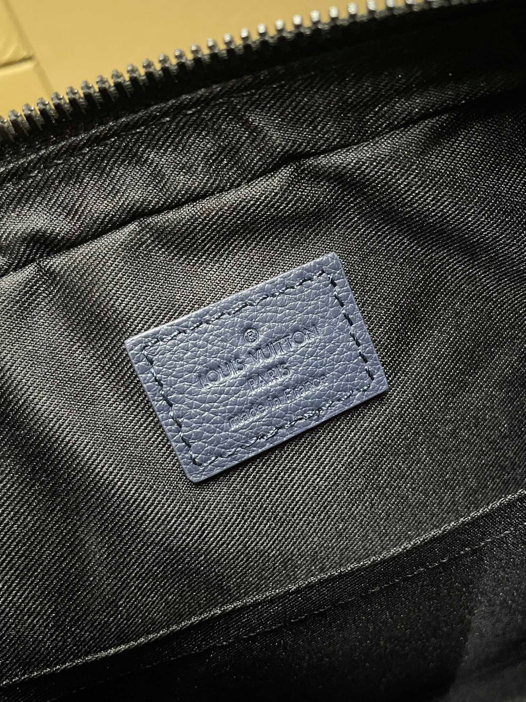 Blue fabric interior pocket with stitched label detail