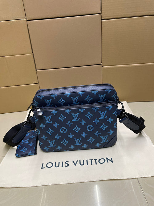 Blue monogram crossbody bag with front flap, dual zippers, and shoulder strap