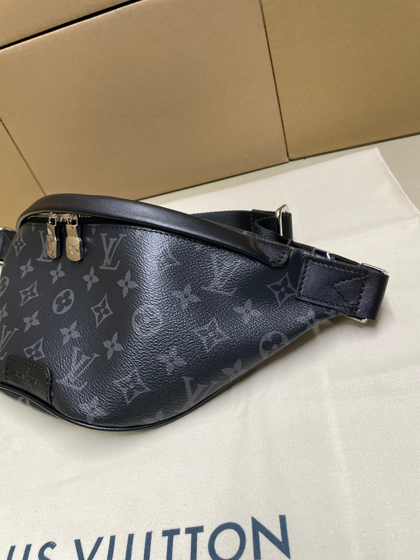 Louis Vuitton monogram waist bag in dark navy, close side view with leather trim