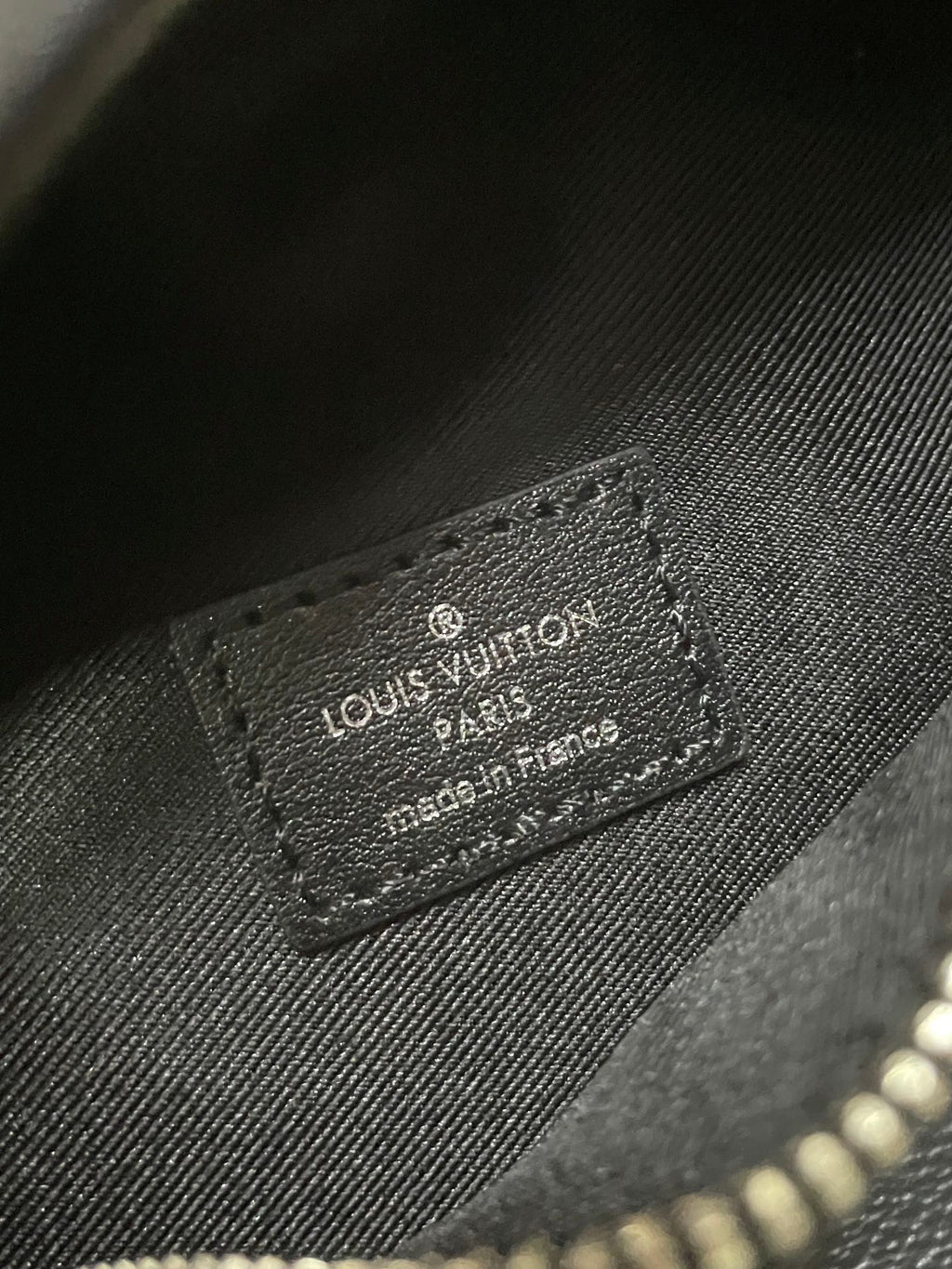 Louis Vuitton leather patch label on monogram waist bag, embossed text