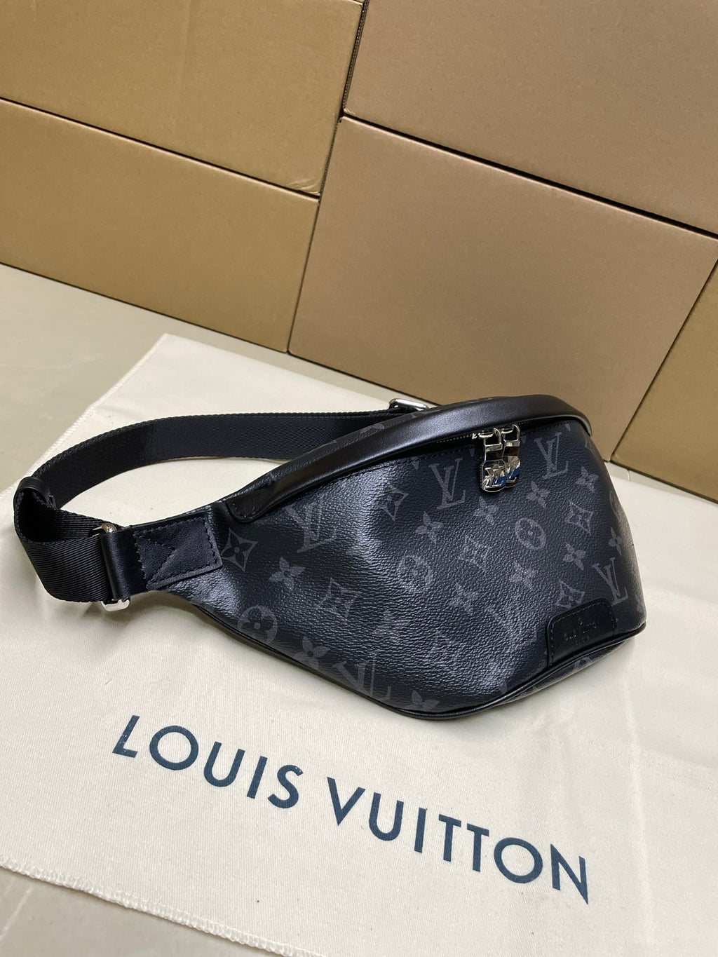 Louis Vuitton monogram waist bag in dark navy, front-left view with adjustable strap