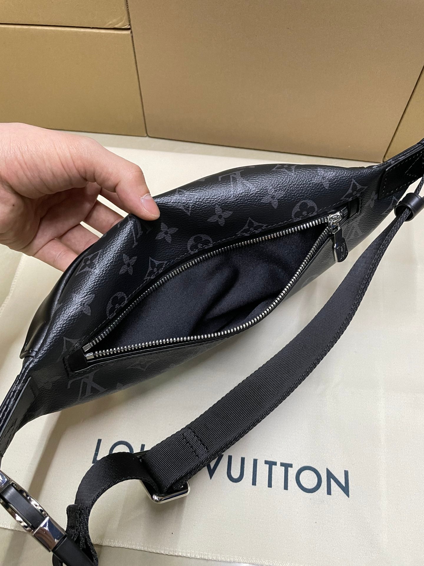 Louis Vuitton monogram waist bag with zip opening, adjustable strap, and front pocket