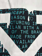 Black crewneck T-shirt close-up of white X emblem over teal text.