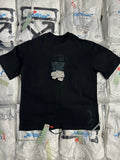 Black graphic T-shirt with large white X-style logo on the chest.