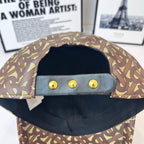 Burberry cap interior with black lining, three gold snap buttons, monogram trim