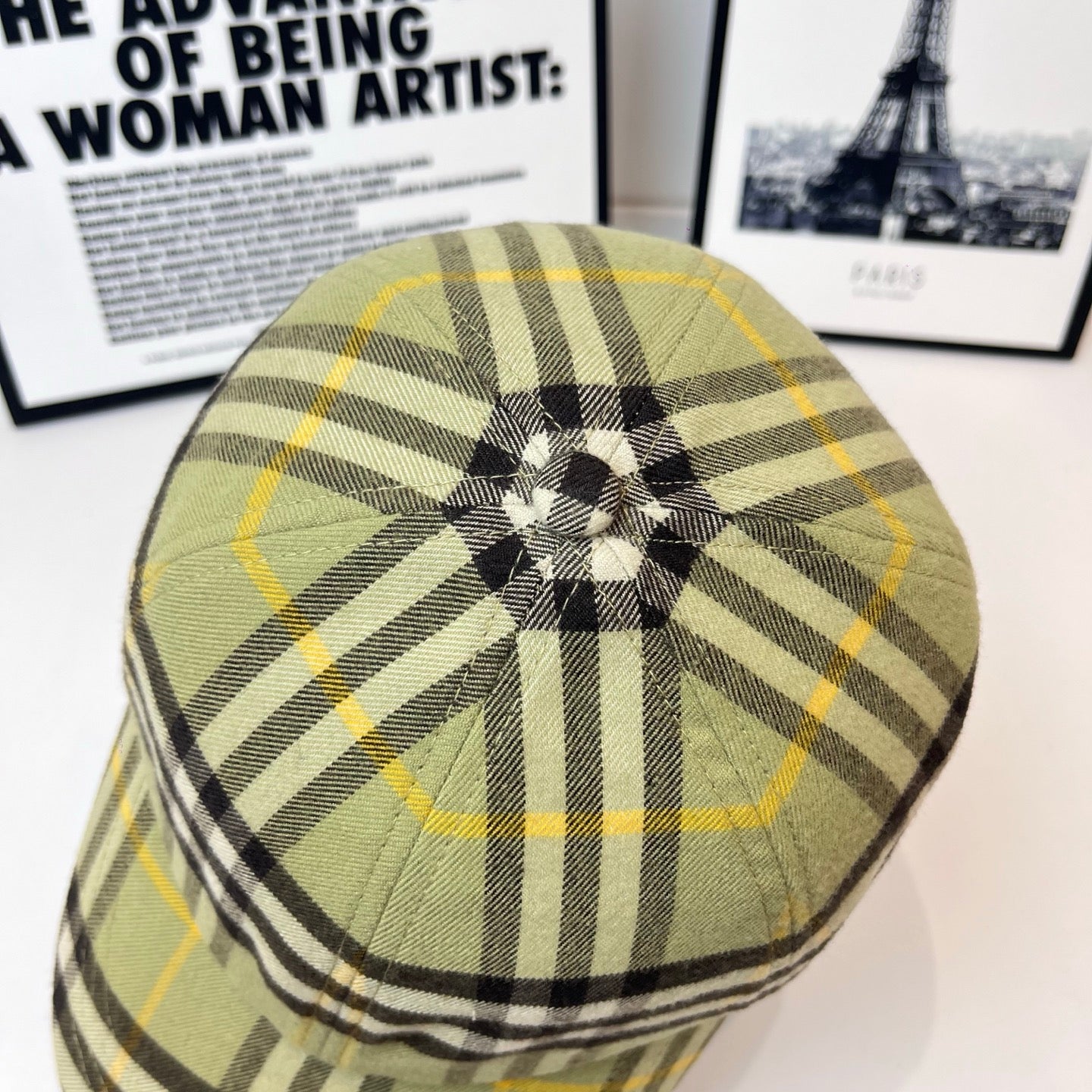 Burberry plaid cap showing crown button, olive, black, and yellow plaid pattern