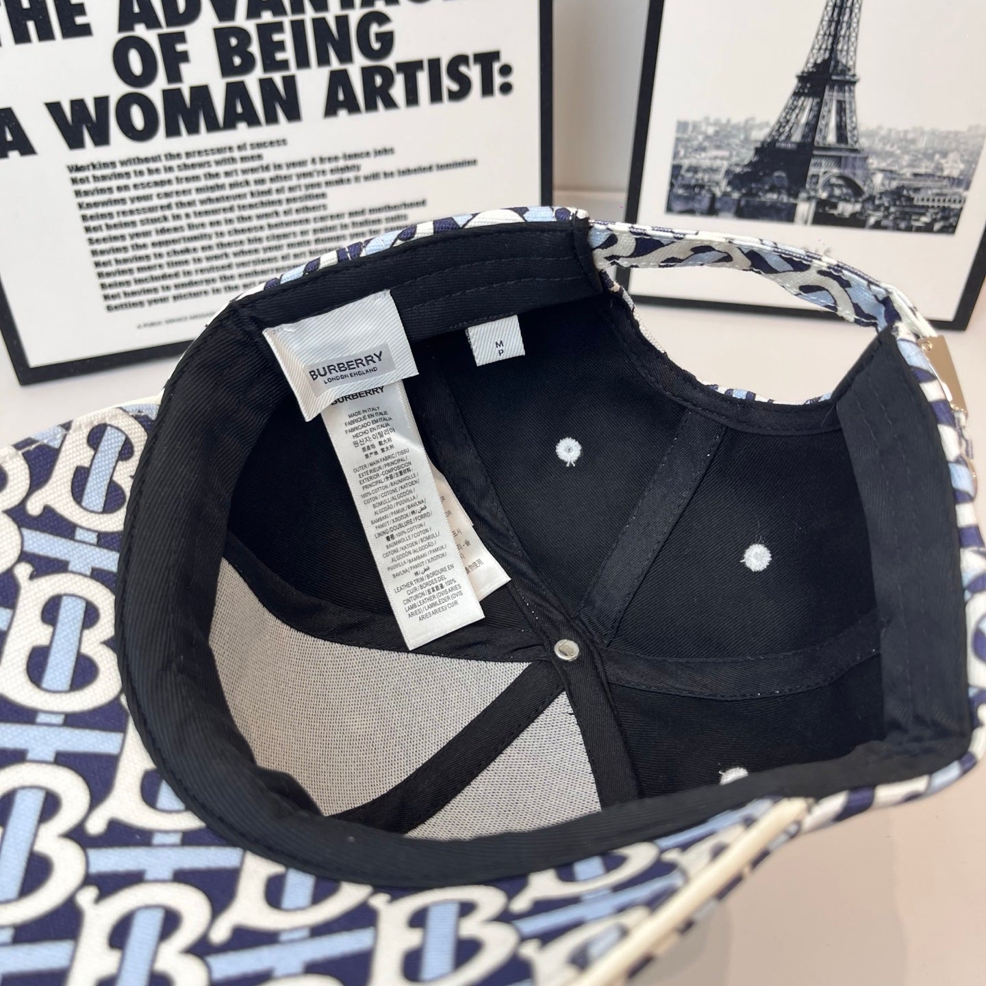 Burberry cap interior with black panels, top button hardware, and fabric brim trim