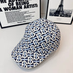 Burberry cap with navy-and-white B logo print and curved brim, side view