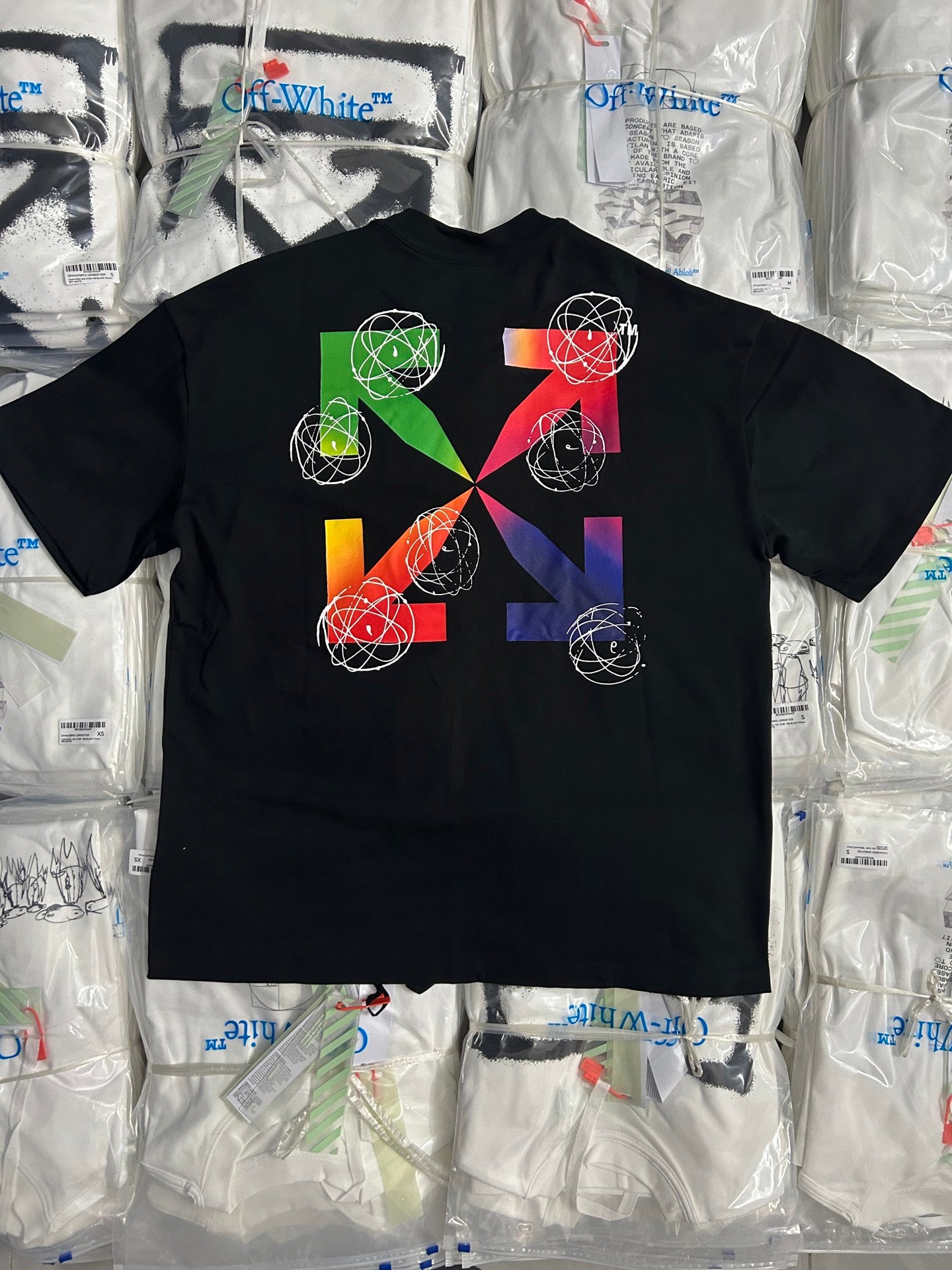 Black T-shirt with multicolor geometric artwork and white orbit-line graphics
