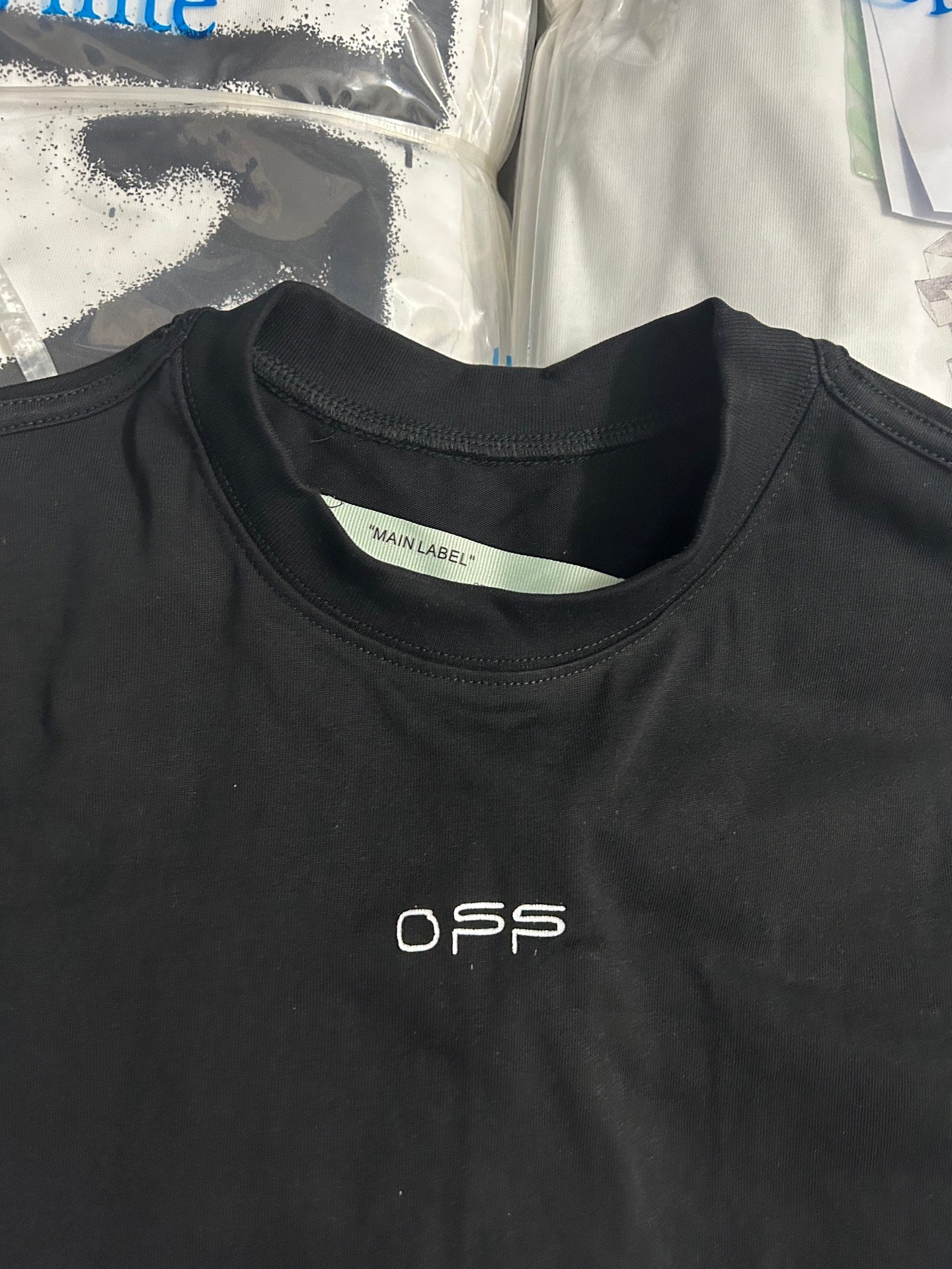Black T-shirt neckline with 'MAIN LABEL' tag and small O.F.S print