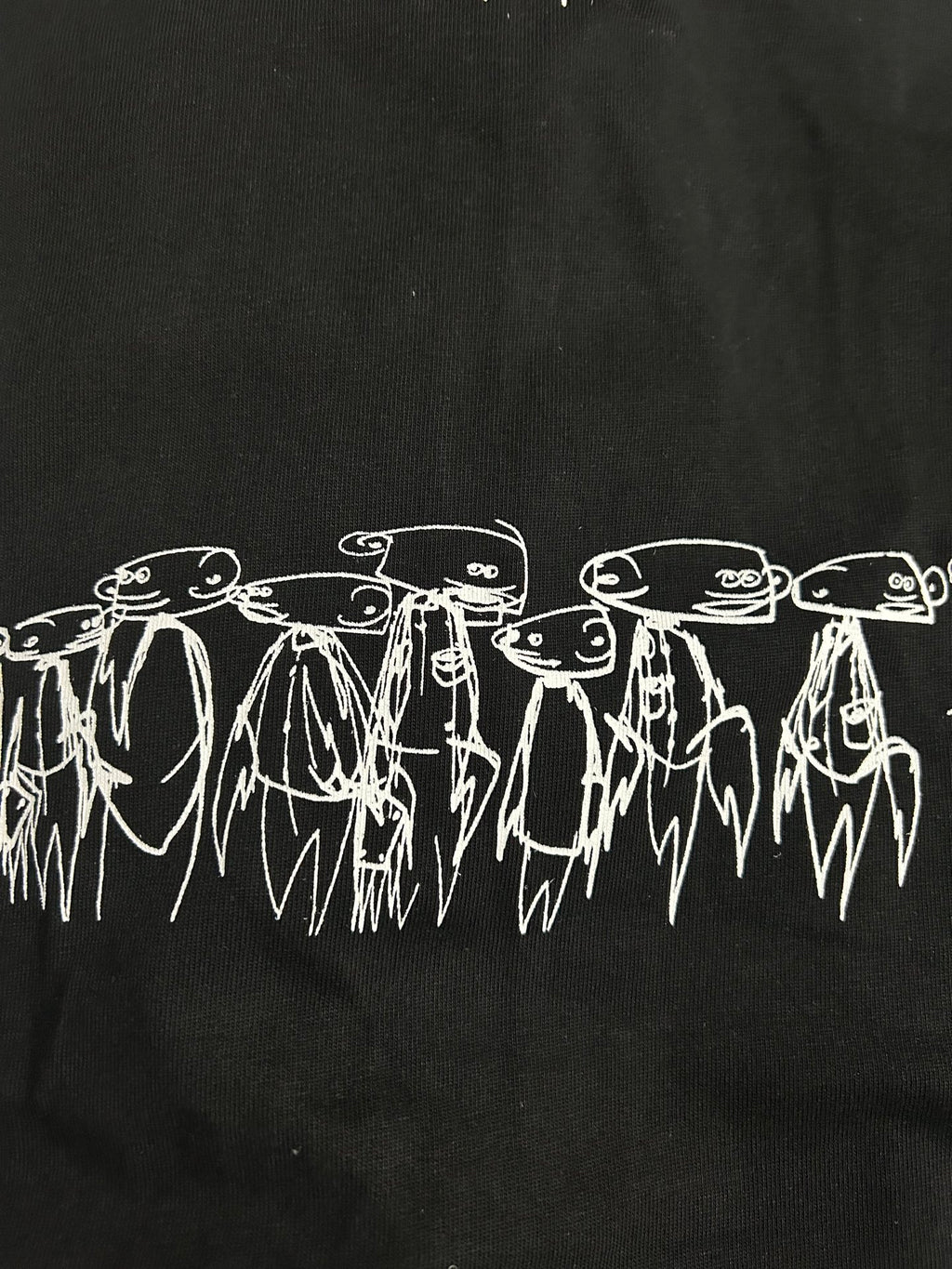Black T-shirt with white illustrated line art figures along the chest