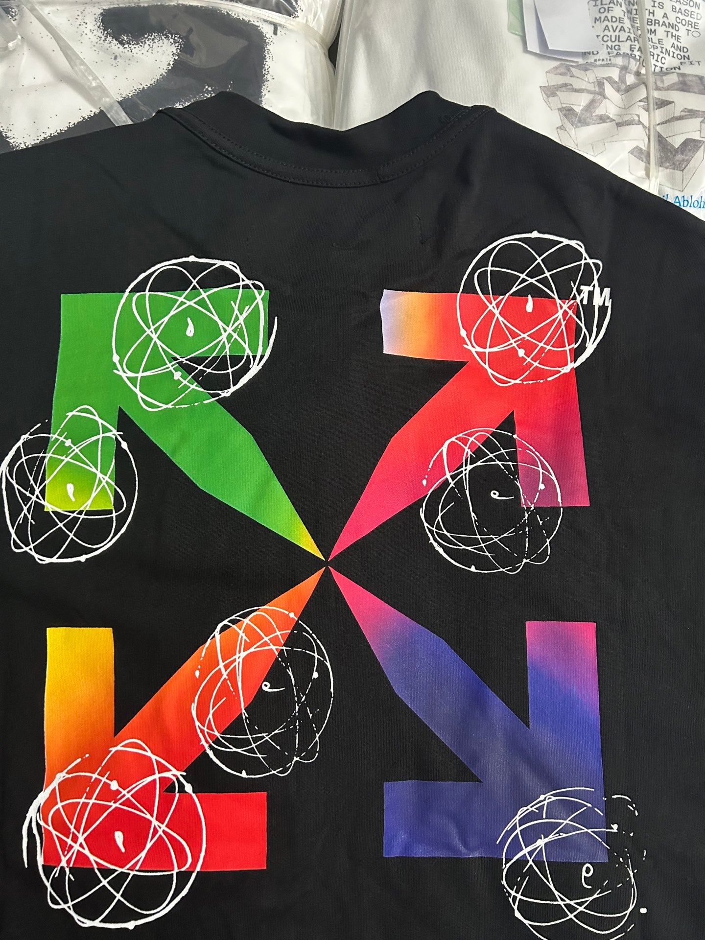 Black T-shirt with colorful geometric print featuring white orbit-line circles