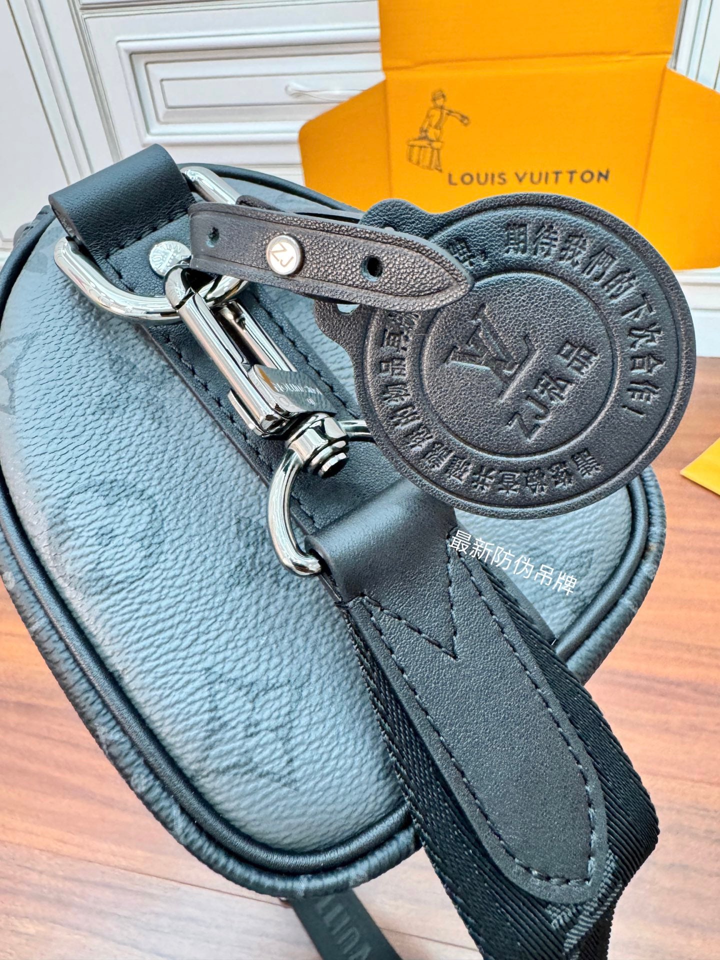 Men's Louis Vuitton monogram bag close-up of leather strap and metal clasp, dark
