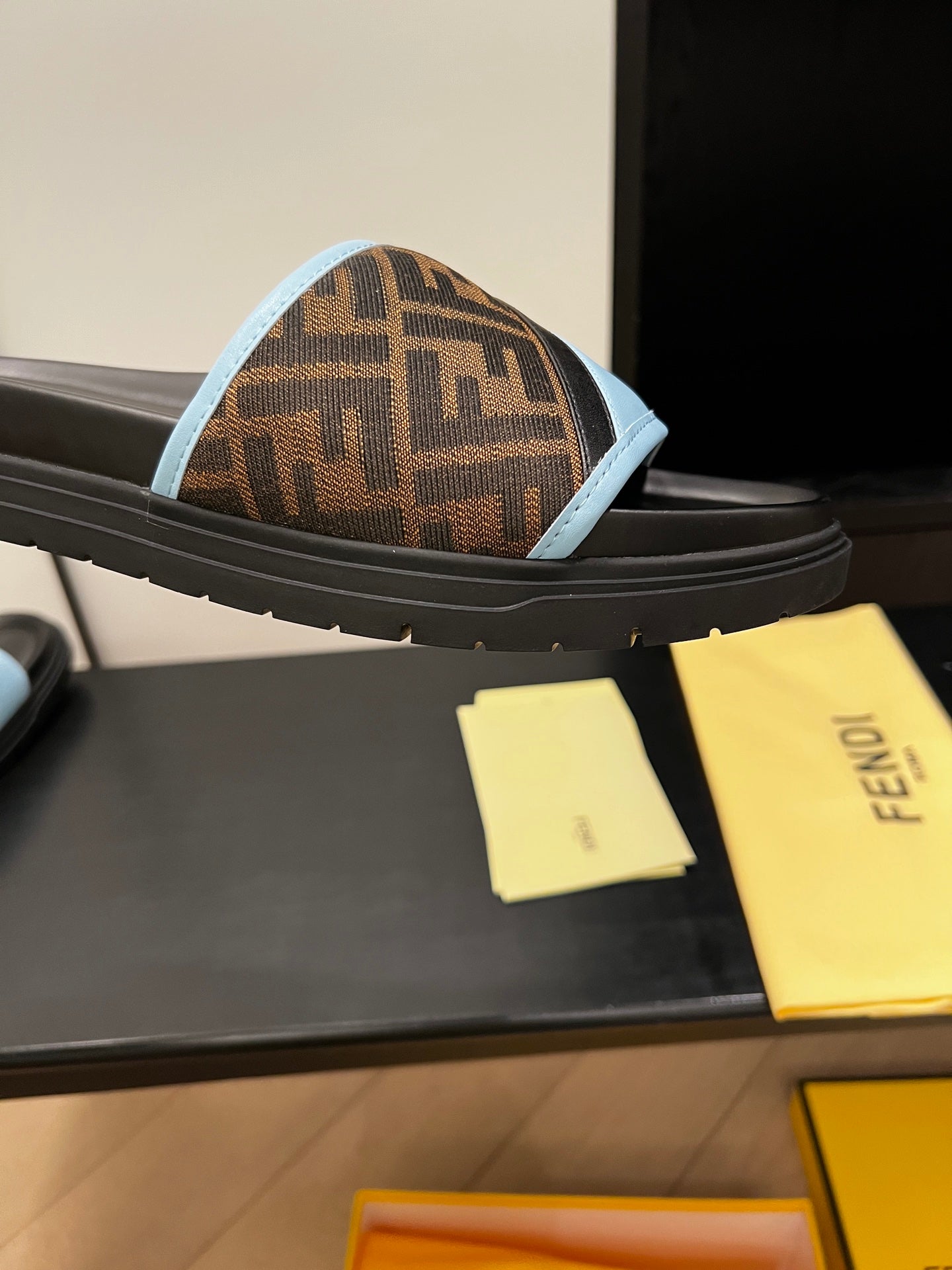 Blue slide sandal with brown FF-logo strap on thick black platform sole