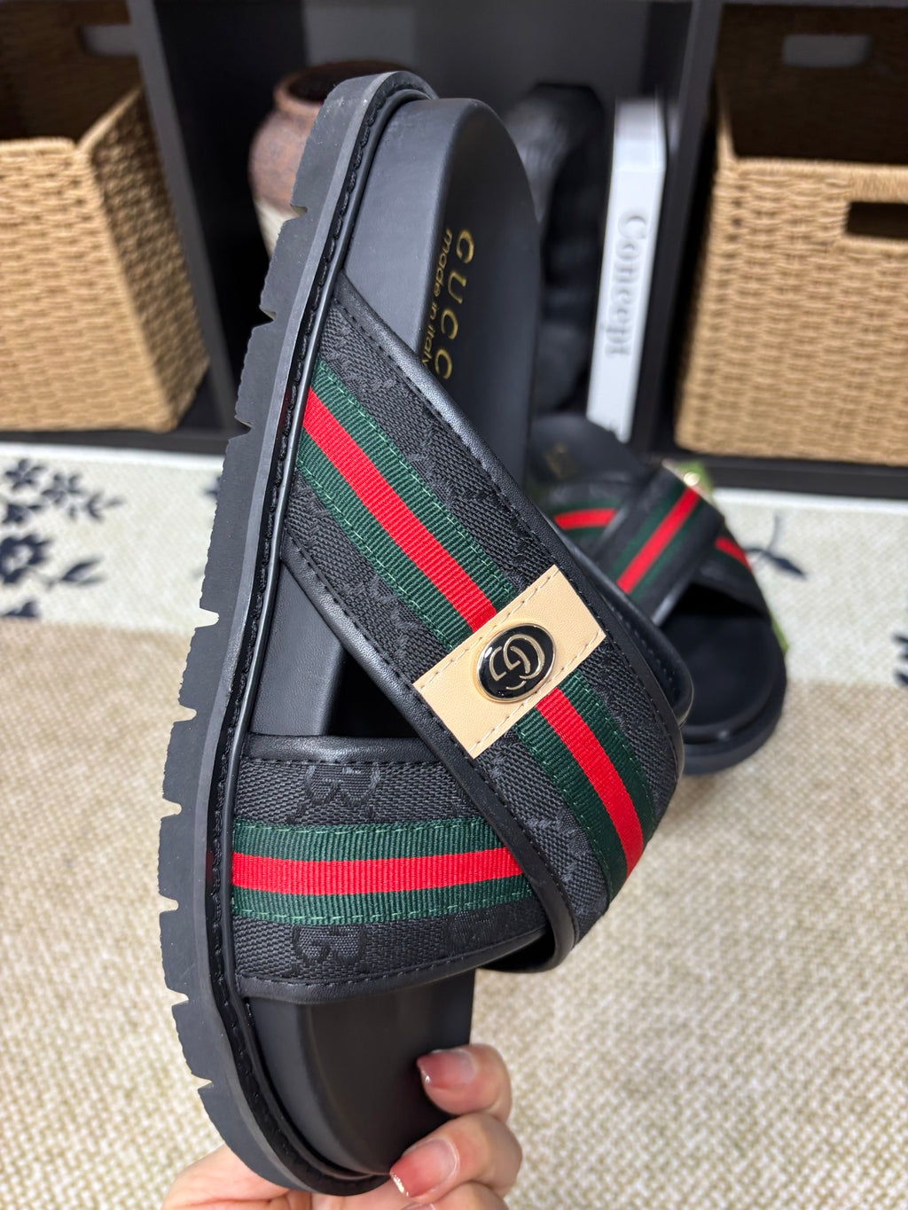 Gucci black slide sandals side view, diagonal green red web strap and badge