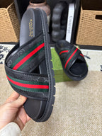 Gucci black slide sandals close-up, green red web stripe and gold buckle