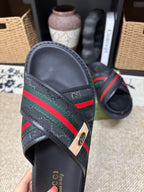 Gucci black slide sandals front view, textured upper with green red web band