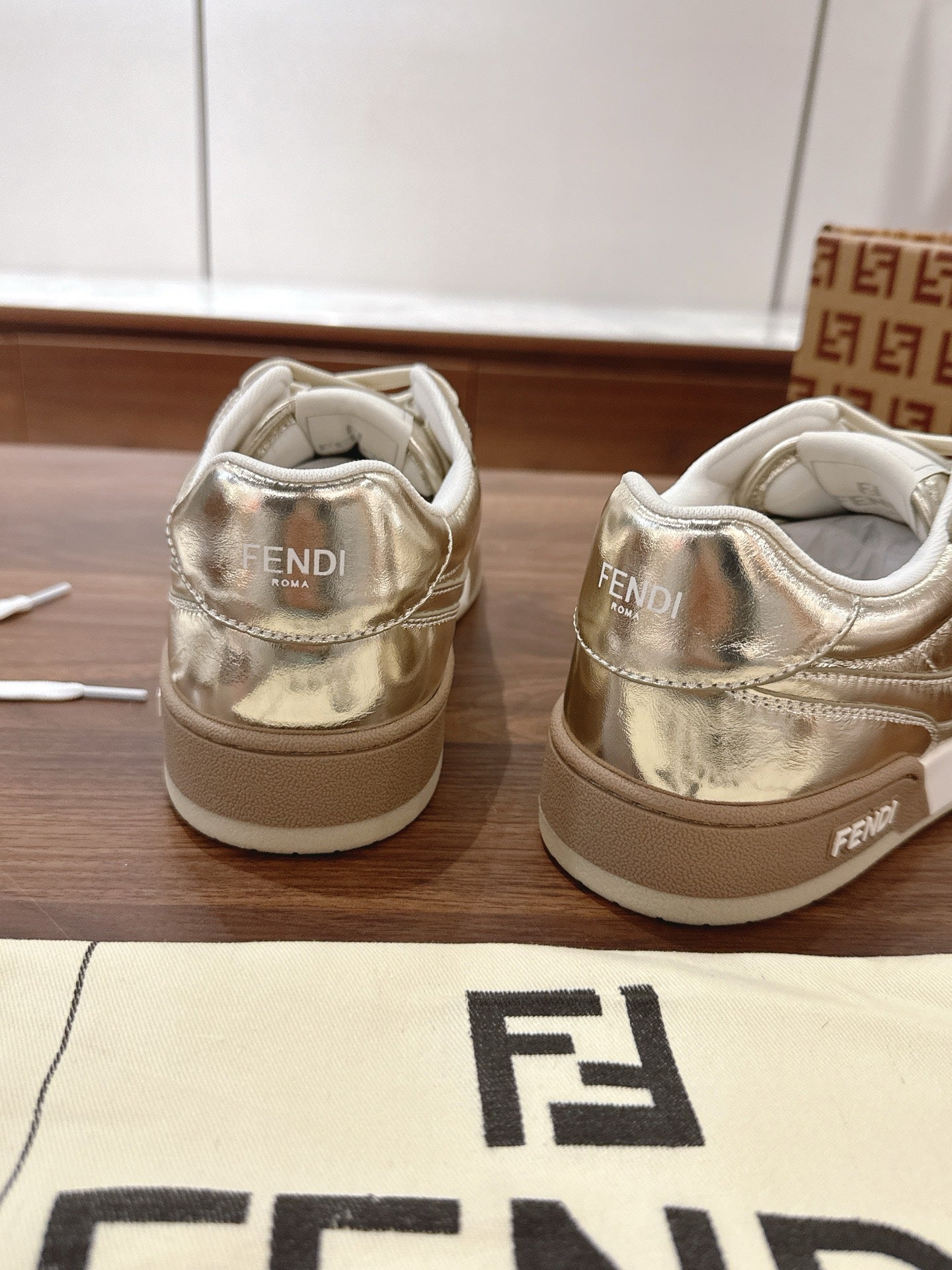 Back view of metallic low-top sneakers with Fendi logo on heel and tongue
