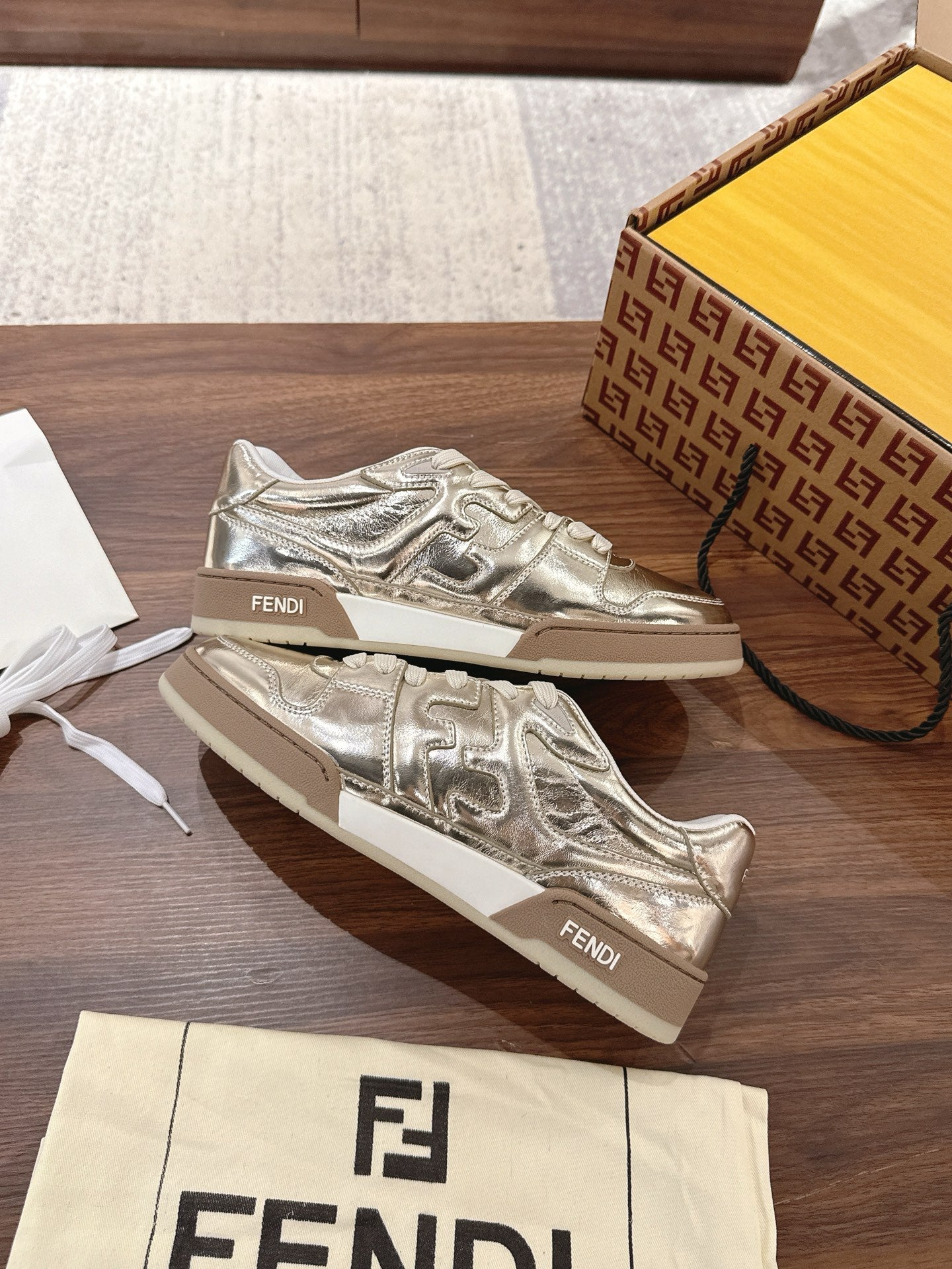 Metallic low-top sneakers with white laces and Fendi branding on tongue and side