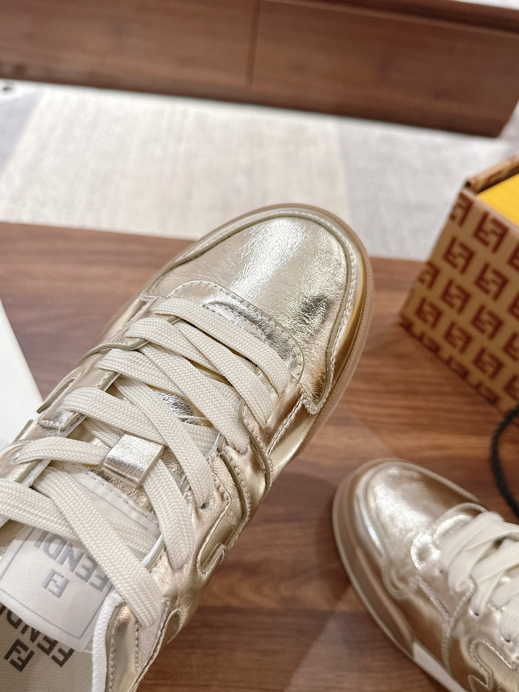 Metallic low-top sneakers close-up with white laces and stitched side detailing