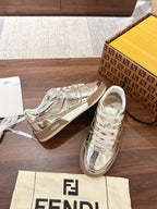 Metallic low-top sneakers with white laces and side logo, set on shoebox lid