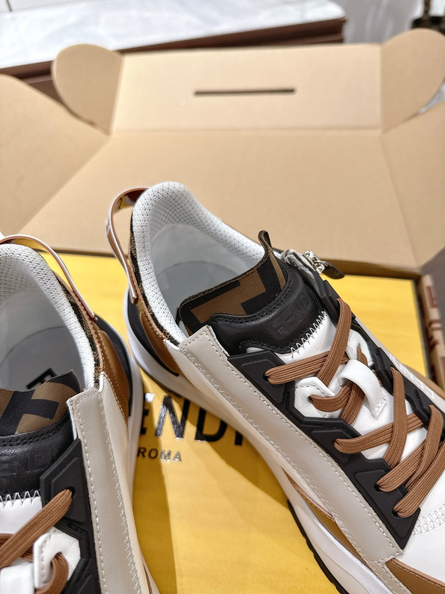 Fendi unisex sneakers close-up: black and brown uppers with white panels and lace-up detail
