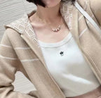 Dior pendant necklace worn with a beige jacket and light top