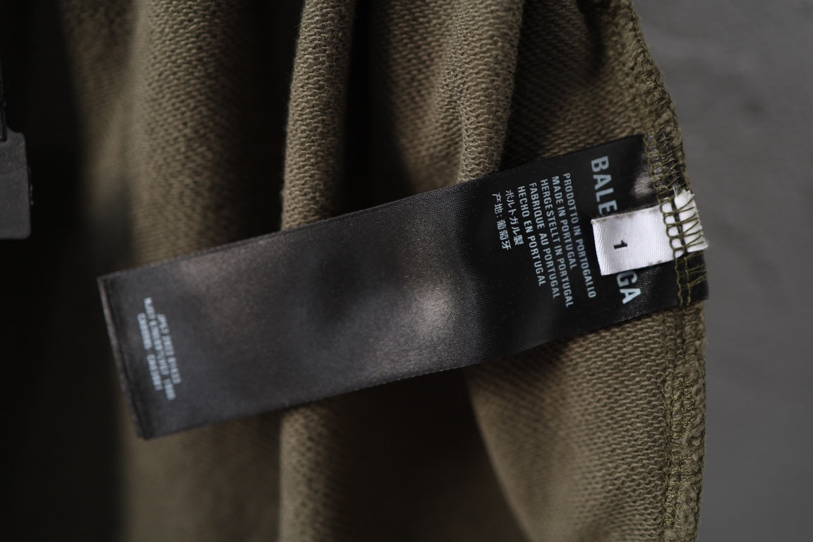 Olive green pants with Balenciaga care label on waistband