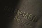 Balenciaga logo embroidery on dark green fabric close-up