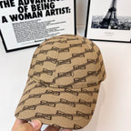 Beige baseball cap with dark chain-link motif, close-up of front panel