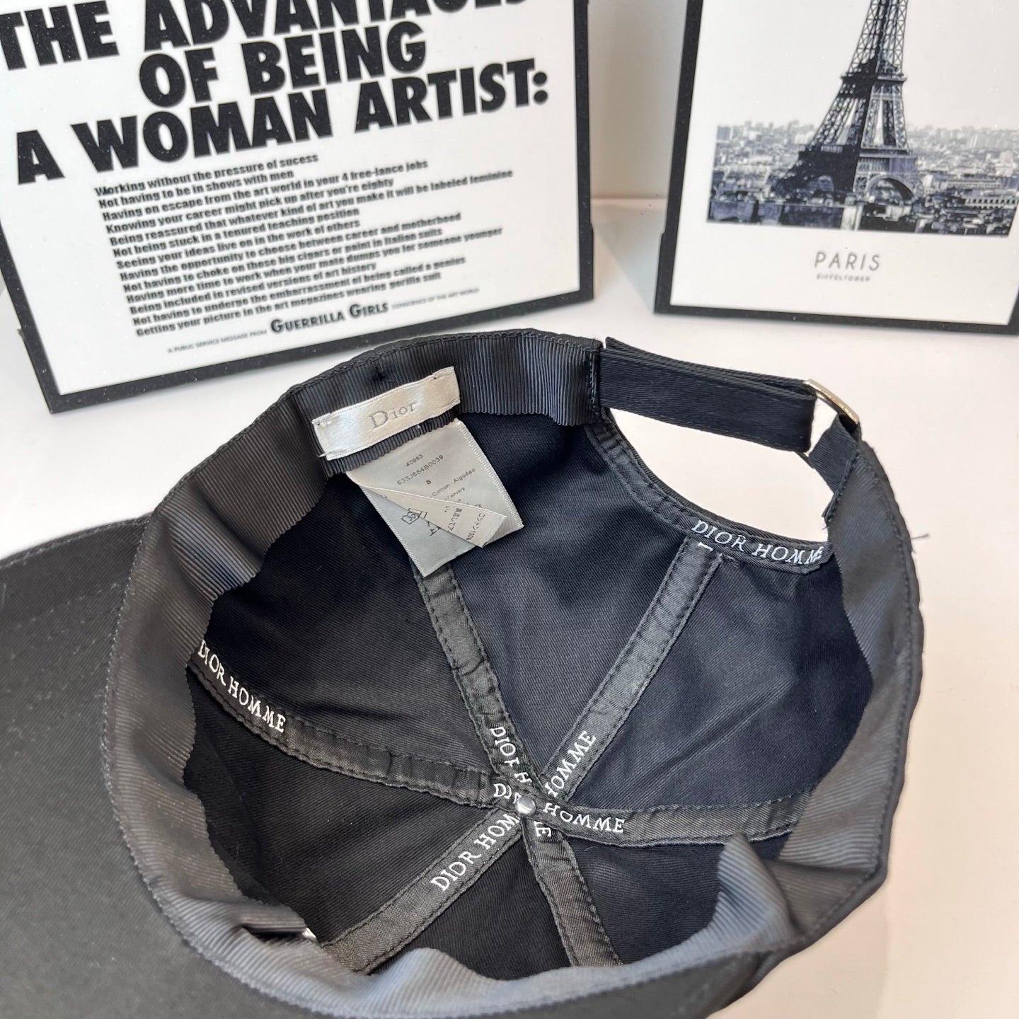 Dior cap interior view with tag and repeating Dior Homme logo on the lining.