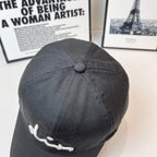 Dior black cap back view with small round button on the crown.